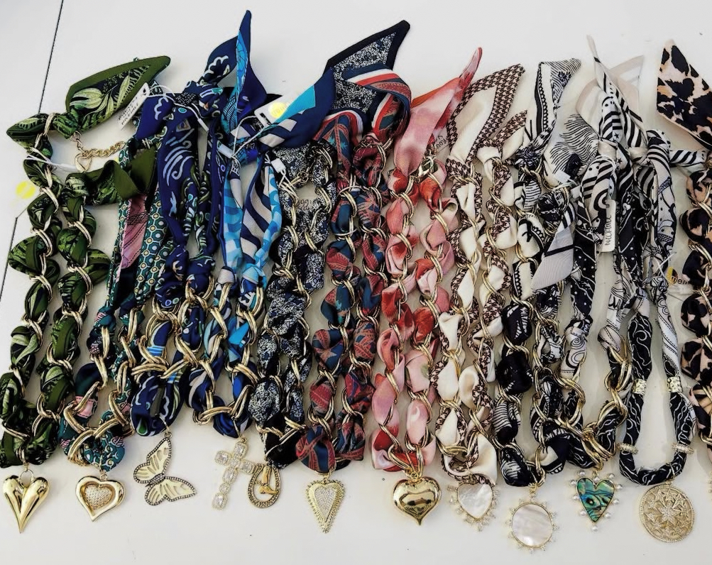 Featuring a soft silk blend scarf intertwined with 18k gold plated chain links and pendant.