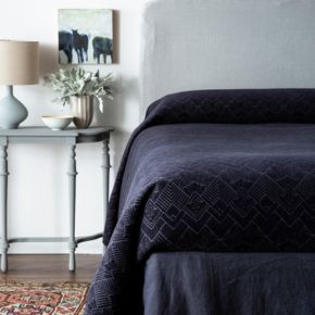 A bed dressed in our Trettino Bedspread in our new colorway, Slate