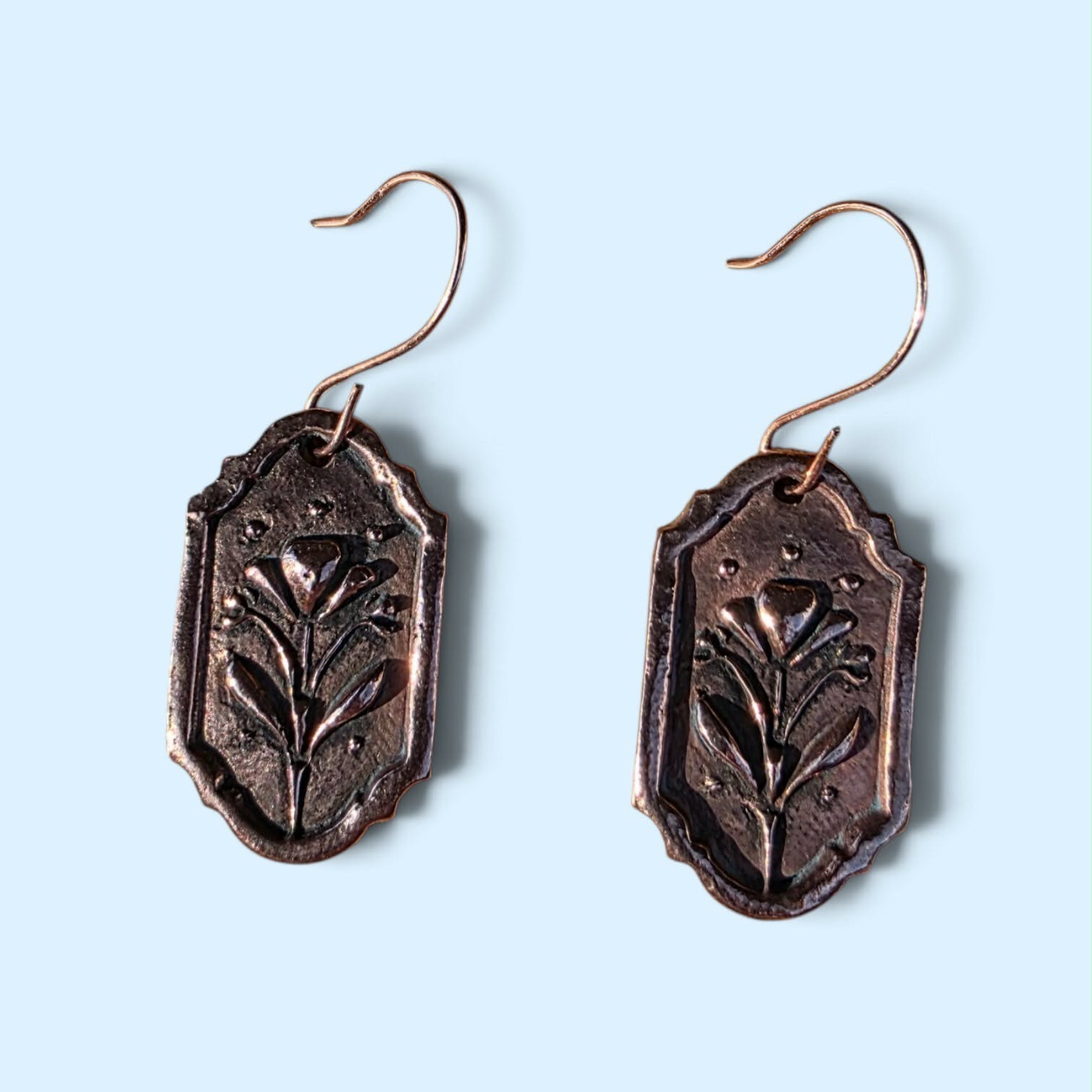 Handcrafted bronze earrings featuring an organic wildflower-inspired texture and rich darkened patina. Each pair has an aged, artifact-like finish that feels botanical, earthy, and one of a kind.