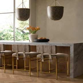 With a slim frame of antique brass and dual cushions of soft taupe suede on the tight seat and back, this counter stool is eye-catching from every angle.