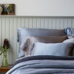 Taline Deluxe Shams shown with Paloma Pillowcases and Taline Throw Pillow at the head of bed dressed in more charmeuse