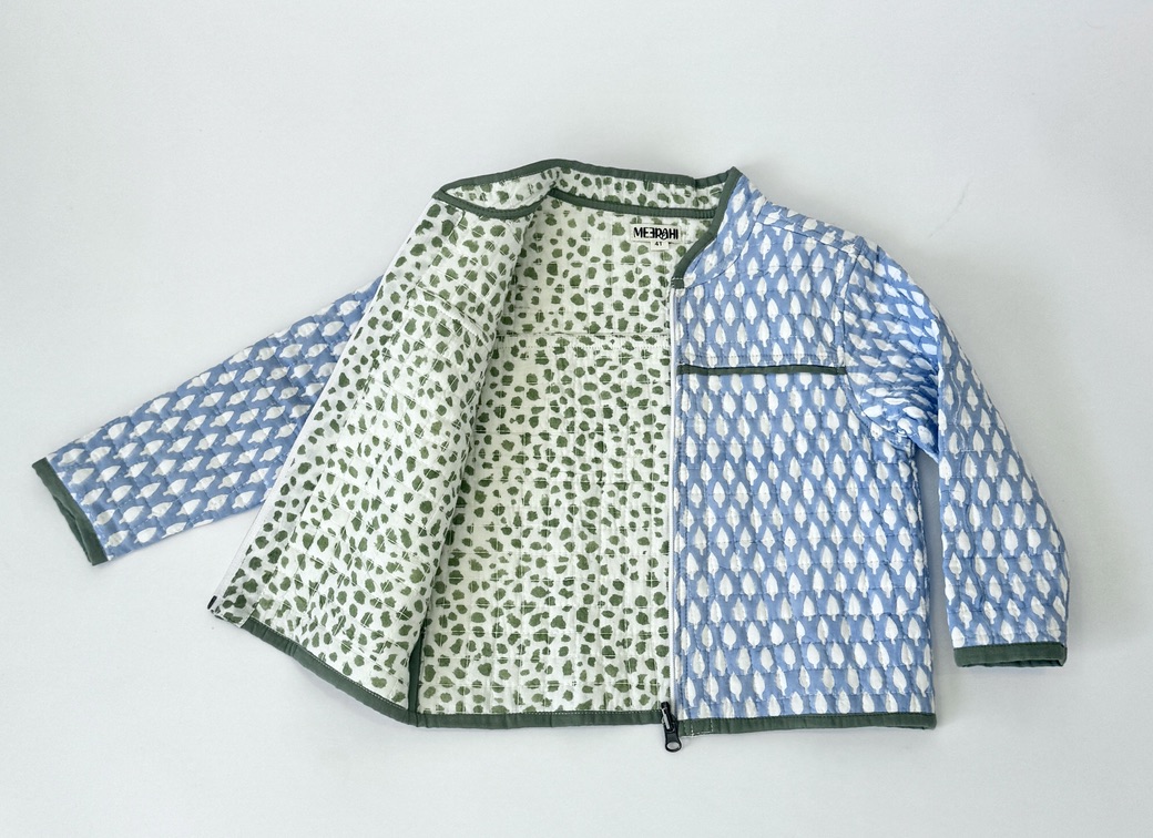 This reversible jacket is handcrafted with blue tree print on one side and fun green polka dot pattern on the other. Quilted on both the sides.  