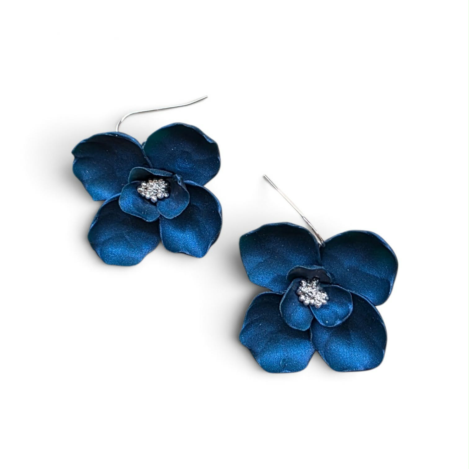Handcrafted polymer clay floral earrings with sculpted petals, rich color, and shimmering centers. Lightweight statement blooms designed to add bold, feminine color without the weight.