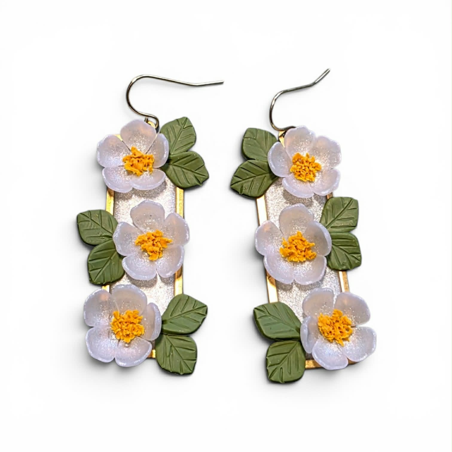 Handcrafted polymer clay earrings from the Grounded Bloom Collection, with sculpted flowers and leaves in symbolic shades of black, terracotta, and white. Lightweight, botanical, and full of meaning.